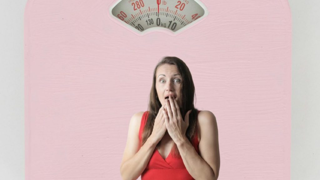 Bilancia in primo piano e donna spaventata