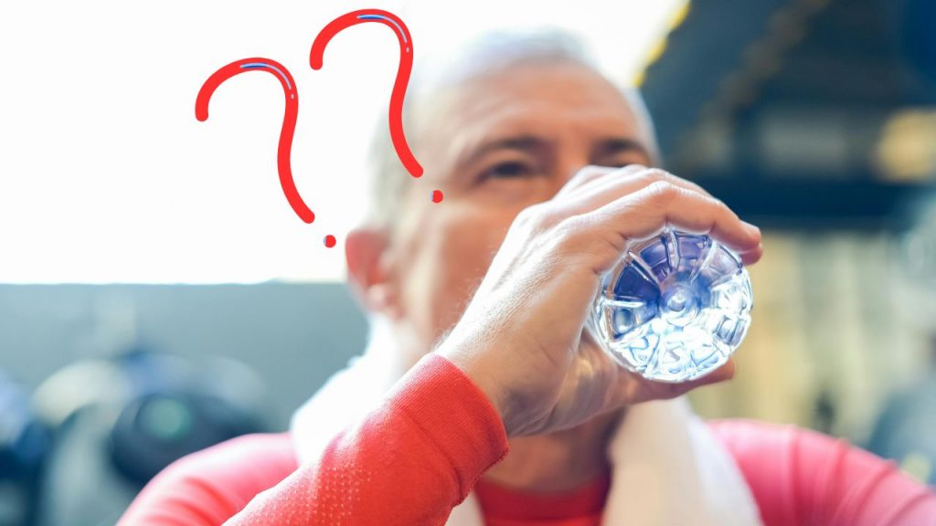 Uomo che beve acqua da una bottiglia di plastica