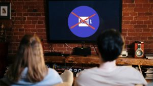 Ragazza e ragazzo seduti davanti alla tv